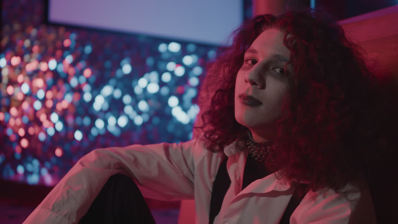 바닥에 앉아서 카메라를 쳐다보는 젊은 남자.