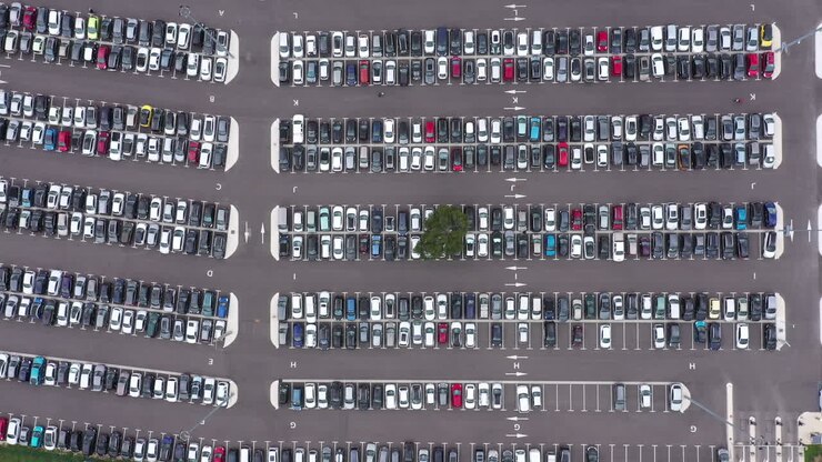 vista aérea de arriba hacia abajo de un estacionamiento con un árbol y lleno de coches. francia