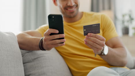 manos, tarjeta de crédito y teléfono en el sofá para en línea