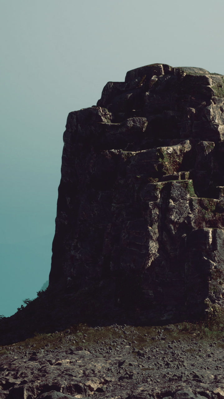 Rock formation by the sea under a clear sky in the afternoon light
