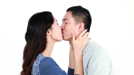 una feliz pareja asiática besándose y sonriendo