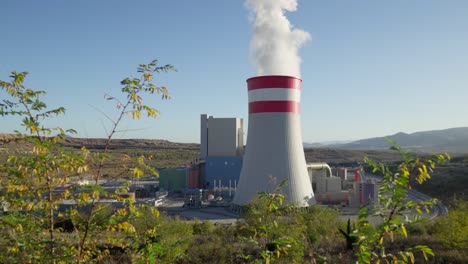 coal fired power station plant cooling towers emitting smoke steam sunny day