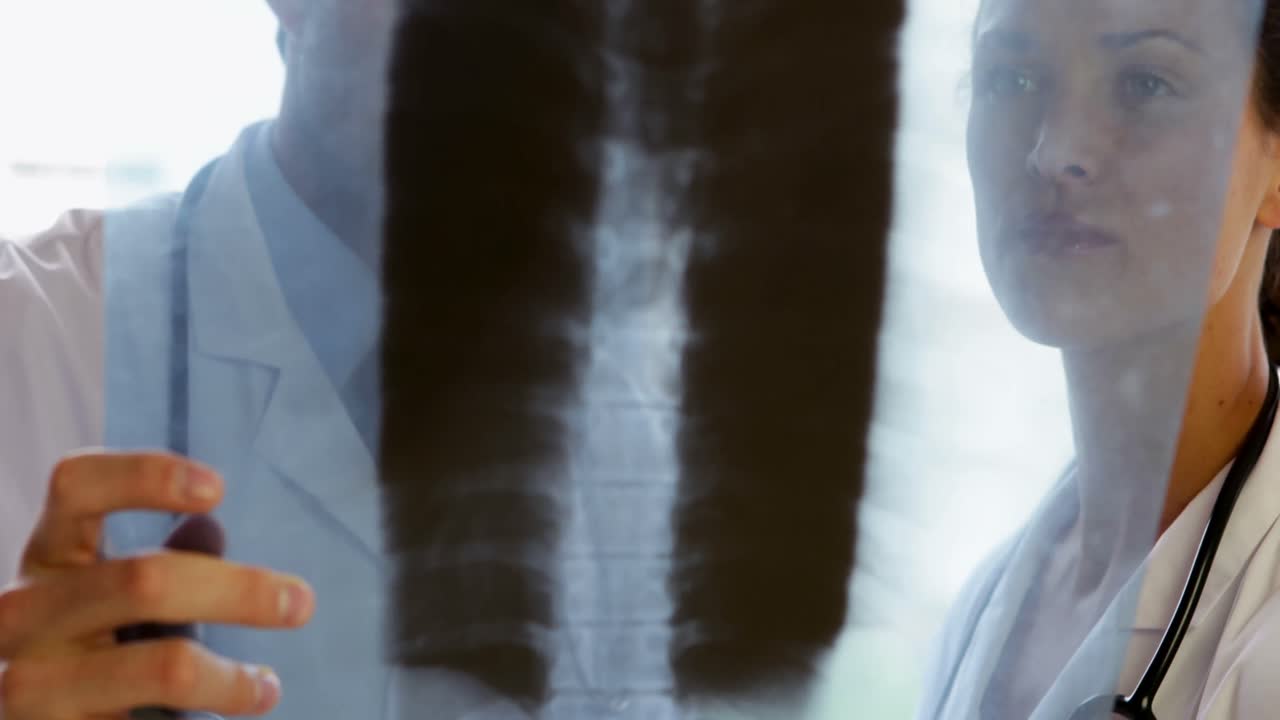 Focused medical team standing and looking at xray