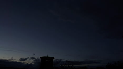 Vista-De-Lapso-De-Tiempo-Del-Cielo-Y-Las-Nubes-Mientras-Cae-La-Noche-Cerca-De-La-Torre-De-Vigilancia-De-La-Era-De-La-Segunda-Guerra-Mundial