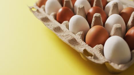 vídeo de huevos en una caja de embalaje en una superficie amarilla