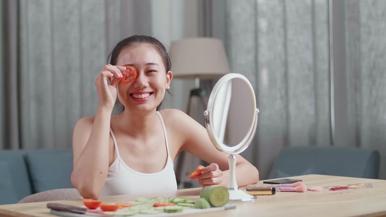 집에서 만든 토마토와 호박 얼굴 마스크를 착용하는 여성