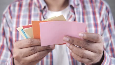 persona que sostiene una pila de tarjetas de colores
