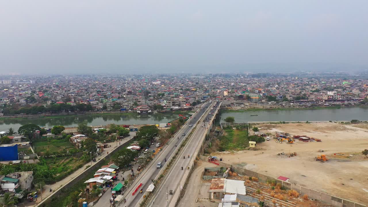 vehículos que cruzan el puente de la carretera sobre el río taguig en la ciudad de taguig, filipinas