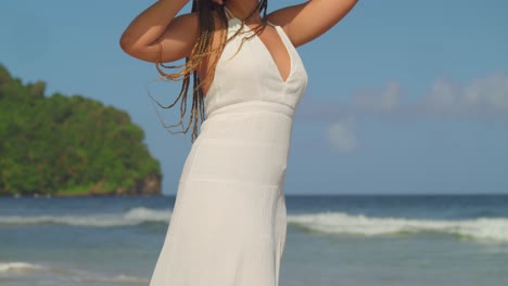 Descending-camera-movement-of-a-woman-shading-under-a-palm-leaf-at-the-beach