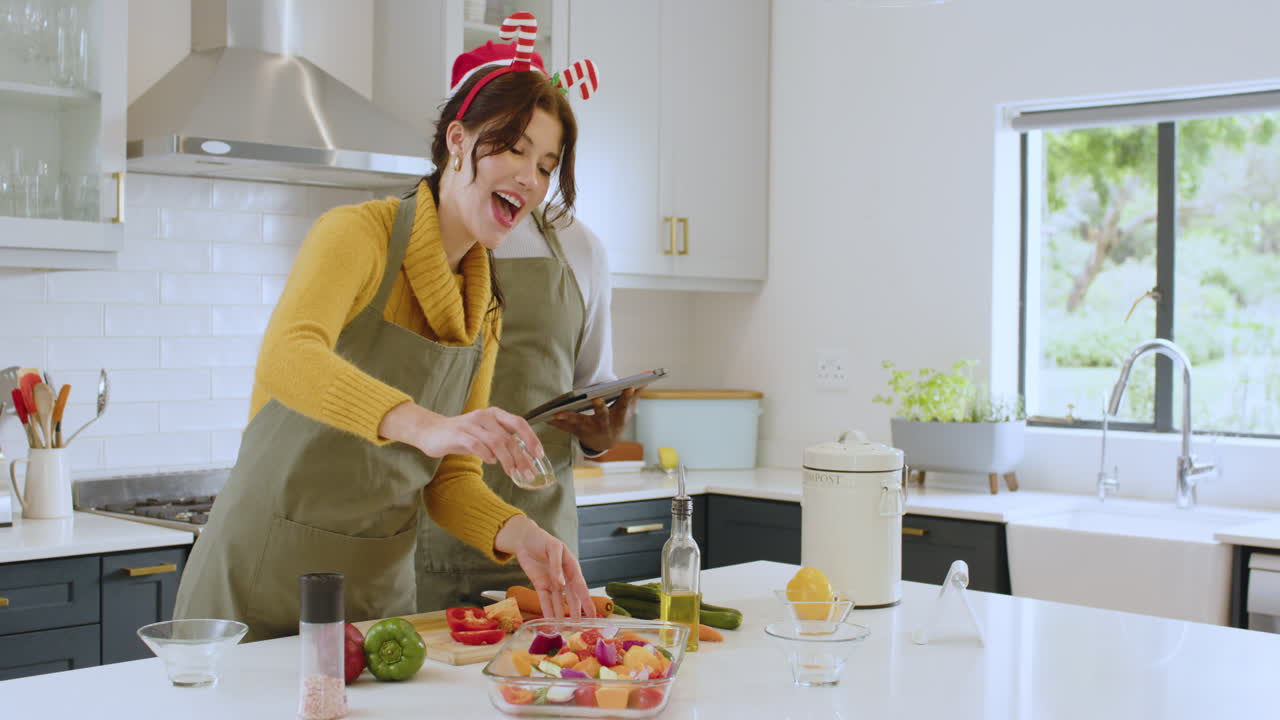 At Christmas, Diverse couple cooking holiday meal together in kitchen, smiling and enjoying