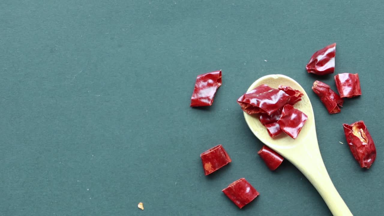 Fiocchi di peperoncino rosso essiccati in un cucchiaio di legno