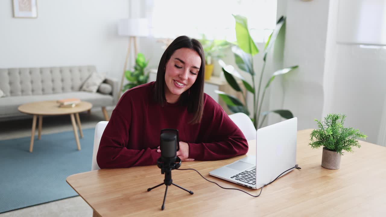 Donna sorridente che registra un podcast con il portatile a casa