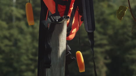 Life-jacket-hangs-to-dry-on-wooden-post-on-pier,-close-up