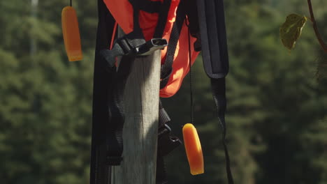 life jacket hangs to dry on wooden post on pier, close-up