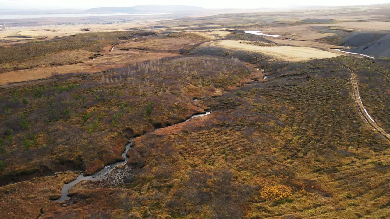 drone volando sobre el hermoso paisaje islandés con pequeños ríos en un día soleado
