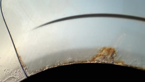 corroded rust remains on the wheel cover rims of a sedan car