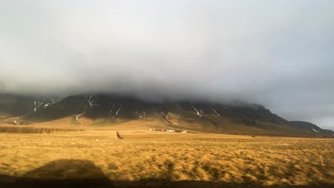 mountain range covered in clouds, seen from hringvegur road in reykjavíkurborg, iceland