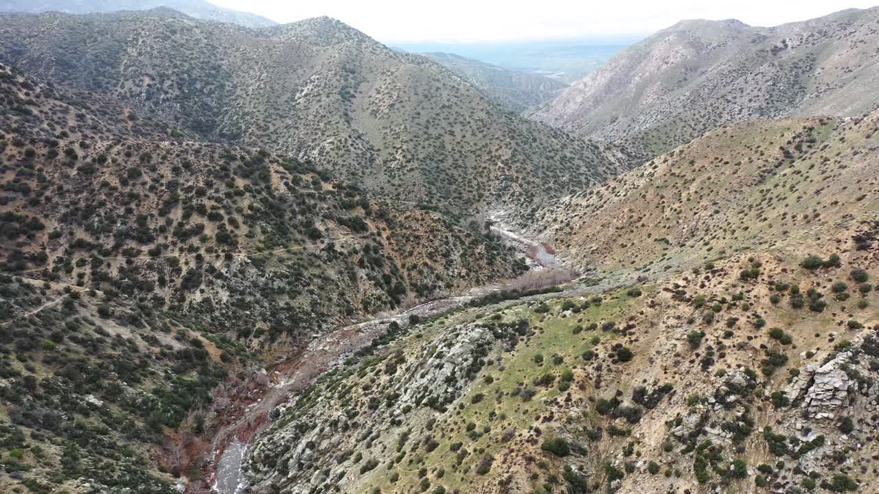 paisaje aéreo dolly sobre un arroyo profundo en el desierto de hesperia en california, estados unidos, durante un día soleado