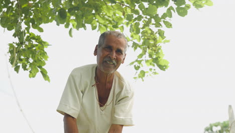portrait of an elderly man under a tree