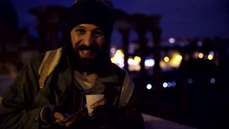 smiling an happy  homeless in the night showing his alms