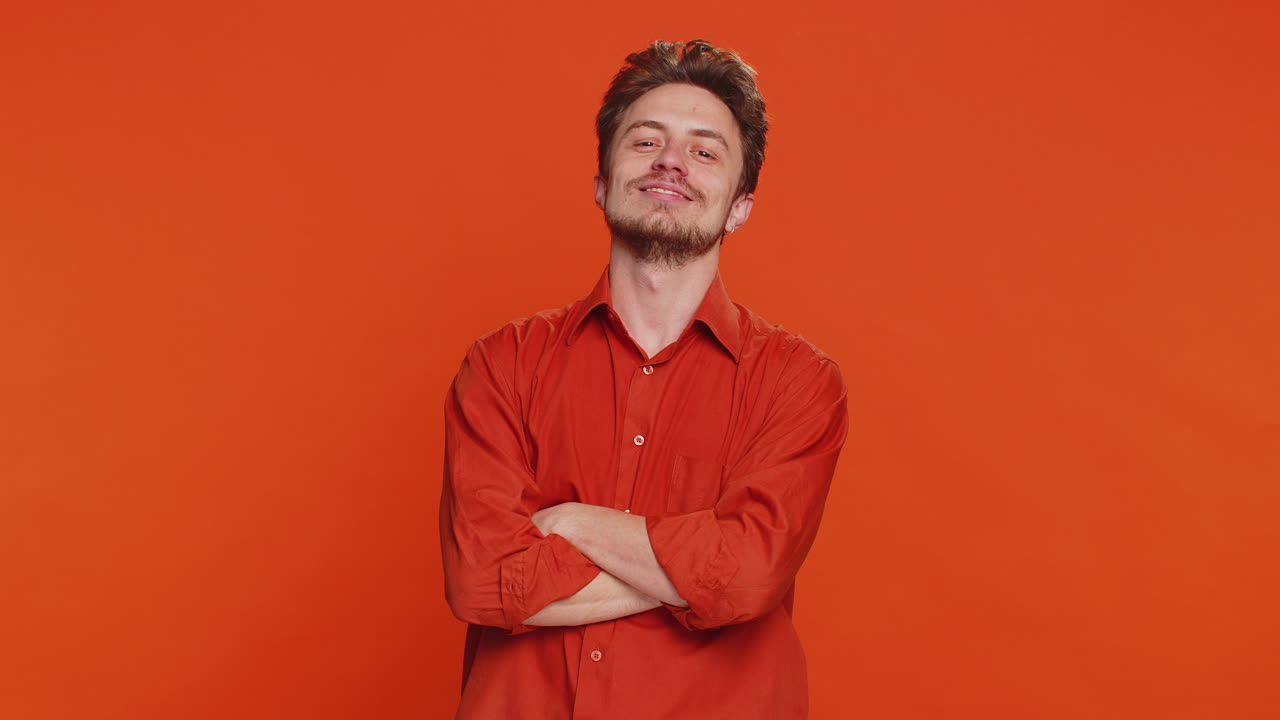 Lächelnder, spielerischer, glücklicher, kaukasischer Mann, blinzelnd, blickt mit einem Lächeln in die Kamera, zwinkert, flirtet.