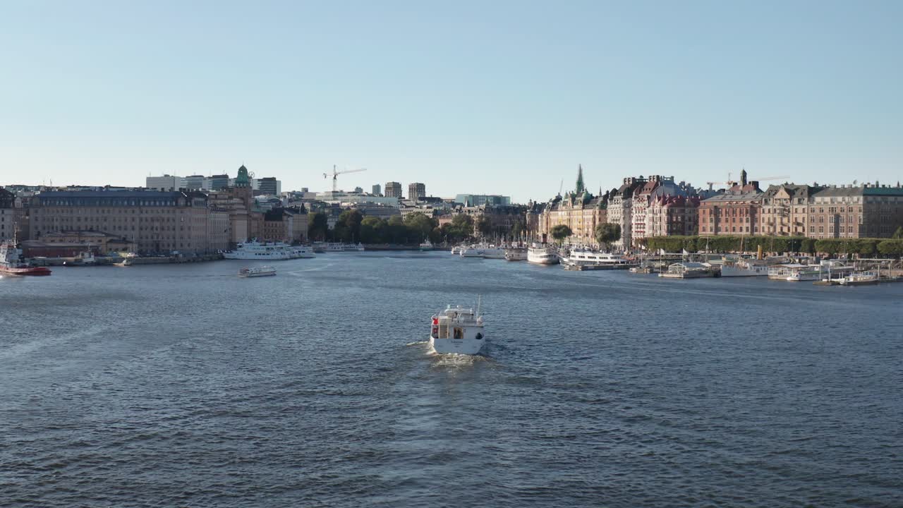 Boat cruising in Ladug&aring;rdlandsviken towards Nybrokajen and Strandv&auml;gen in Stockholm, Sweden during sunny evening