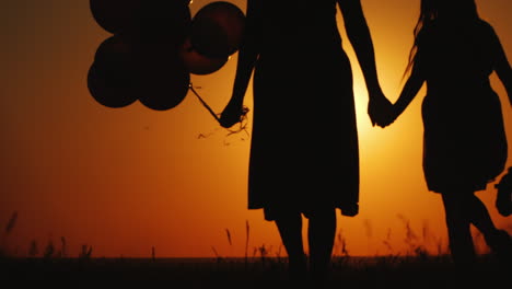 Mom-And-Daughter-Walking-At-Sunset-Air-Balloon-And-Teddy-Bear-Are-Carried