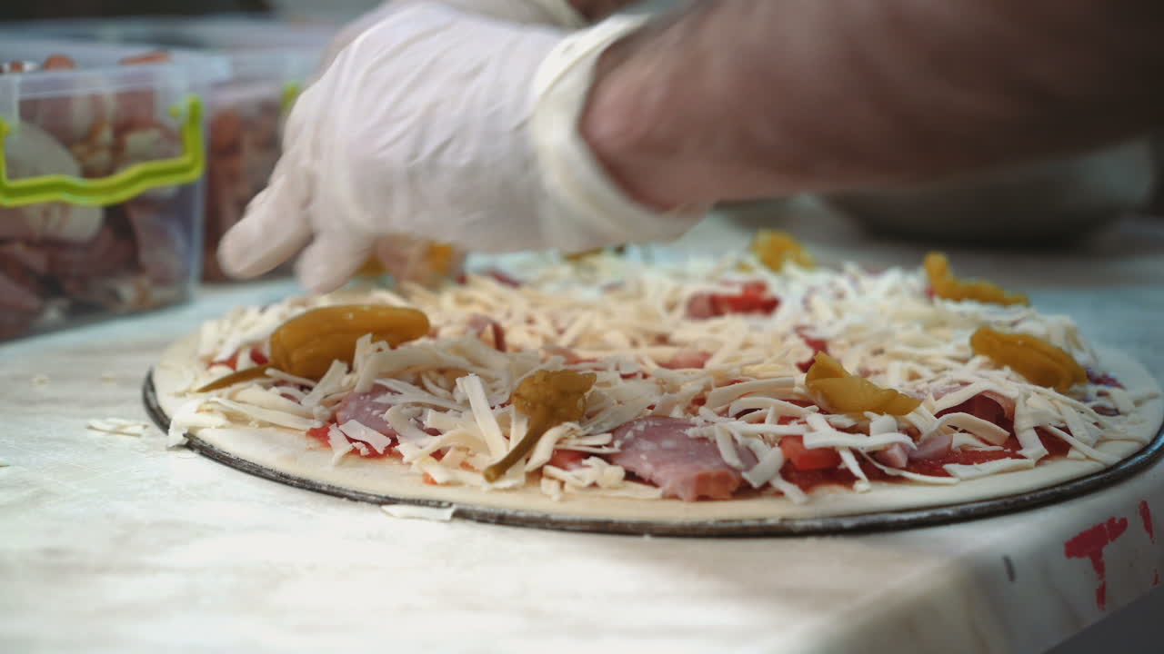 Chef che preparano la pizza in una cucina commerciale. Pizzeria. Preparazione del cibo. Pizzaiolo.