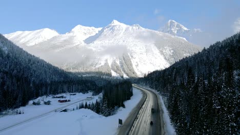 Camiones-De-Carga-Y-Automóviles-Que-Circulan-Por-La-Pintoresca-Carretera-Transcanadiense-1-Rodeados-De-Majestuosas-Montañas-En-Un-Día-Soleado-De-Invierno-Cerca-De-Revelstoke,-Columbia-Británica,-Canadá