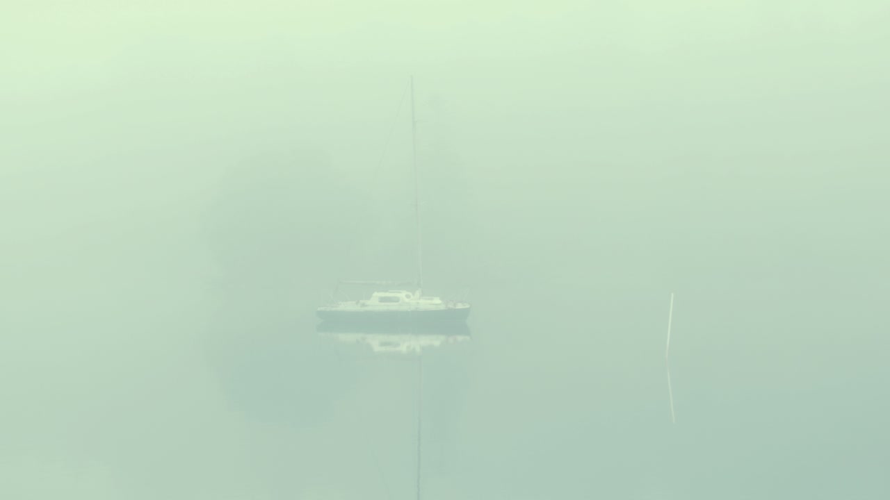 호수 짙은 안개에 정박한 작은 합판 범선