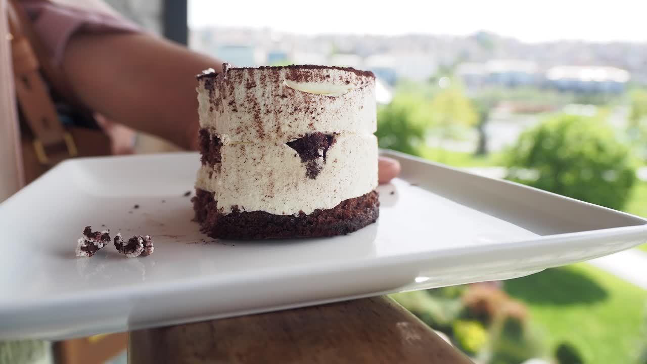 una mujer comiendo tiramisu.