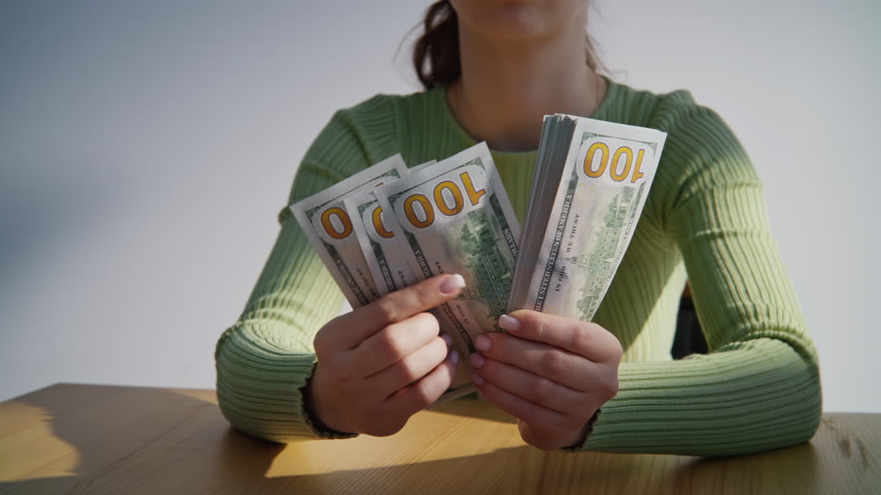 Businesswoman hands holding bills dollar pack indoors closeup. Calculating money