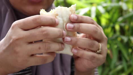 una mujer comiendo un envoltorio.