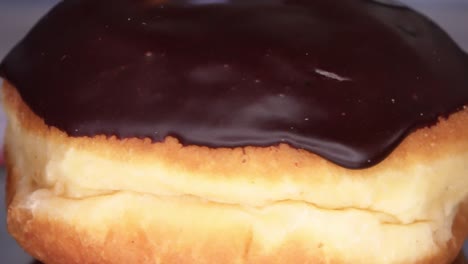 loopable close-up of a spinning berliner with chocolate coating.