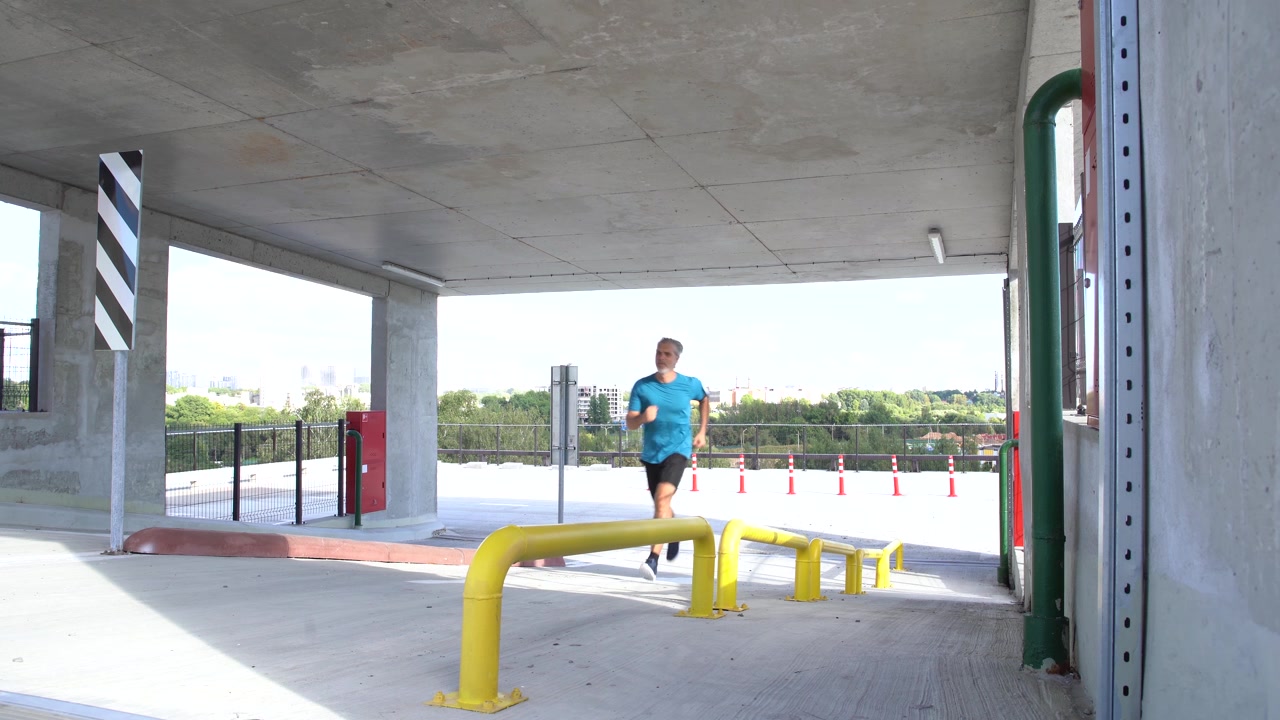 Homme d'âge mûr faisant du jogging dans un parking ouvert