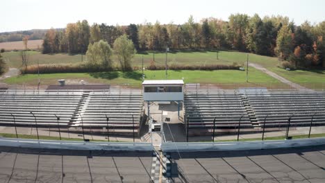 whittemore small track car racing speedway in whittmore , michigan with drone video pulling out and up