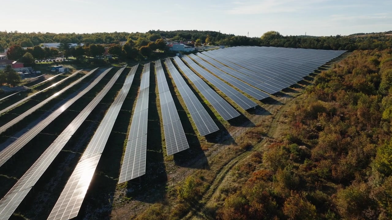 Stor solcellepark med mange solcellepaneler udnytter vedvarende energi i et landområde under