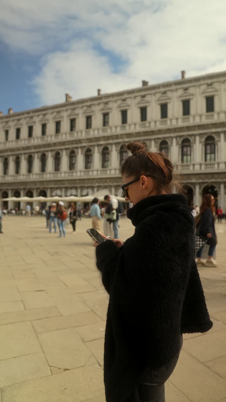 베네치아 성 마르코 광장에서 전화를 사용하는 여성