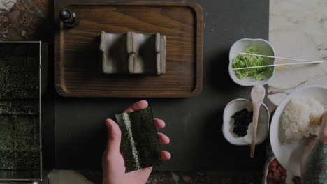 top down shot of a chef preparing a sushi hand roll