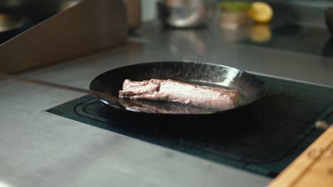 sizzling delights: masterful chef roasting mouthwatering deer meat dish in a pan