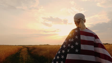 farmer with usa flag walking on a wheat field sun at sunset steadicam shot