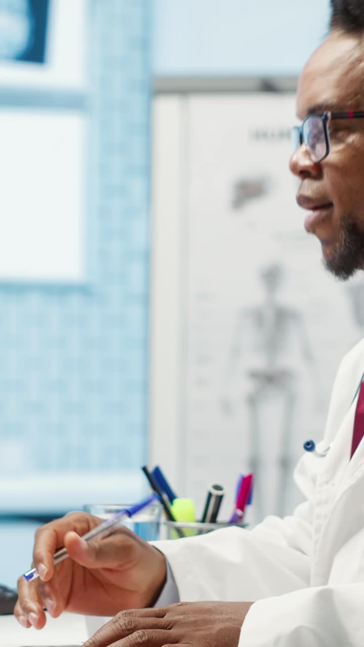 Medico afroamericano che prende appunti e discute in uno studio medico