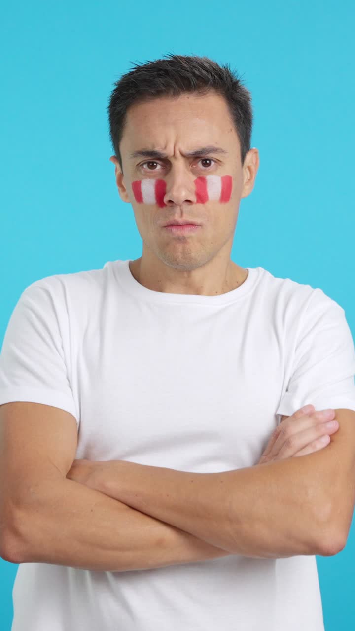 Dignified and serious man with peruvian flag painted on face