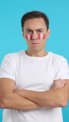 Dignified and serious man with peruvian flag painted on face