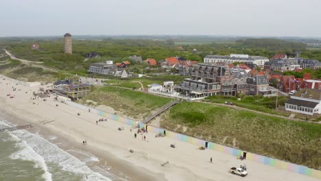 Toma-Aérea-De-La-Playa,-El-Mar-Y-El-Histórico-Pabellón-De-Baño-De-La-Ciudad-De-Domburg-En-Zelanda,-Países-Bajos,-En-Un-Día-Nublado-De-Verano