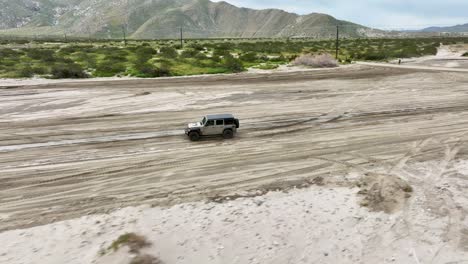 jeep running on mud in the desert of ca palm springs with mountains in the back