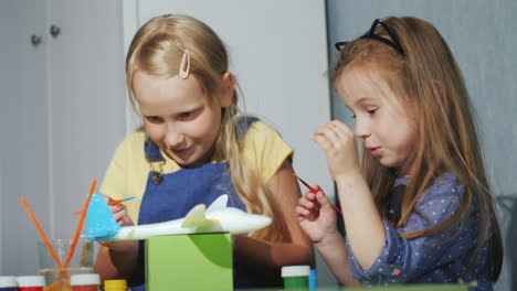 two children together paint a model of a somet with watercolors lessons for the development of child