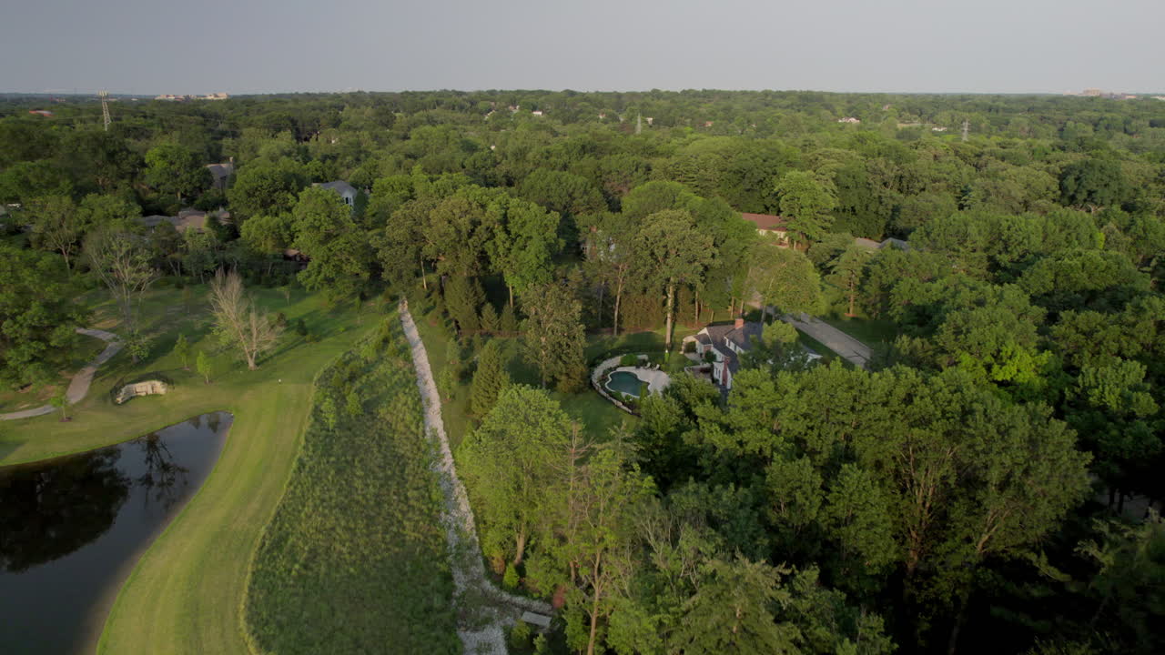 sobrevuelo de un estanque del parque, árboles y casas en un hermoso vecindario en la ciudad y el campo en st.