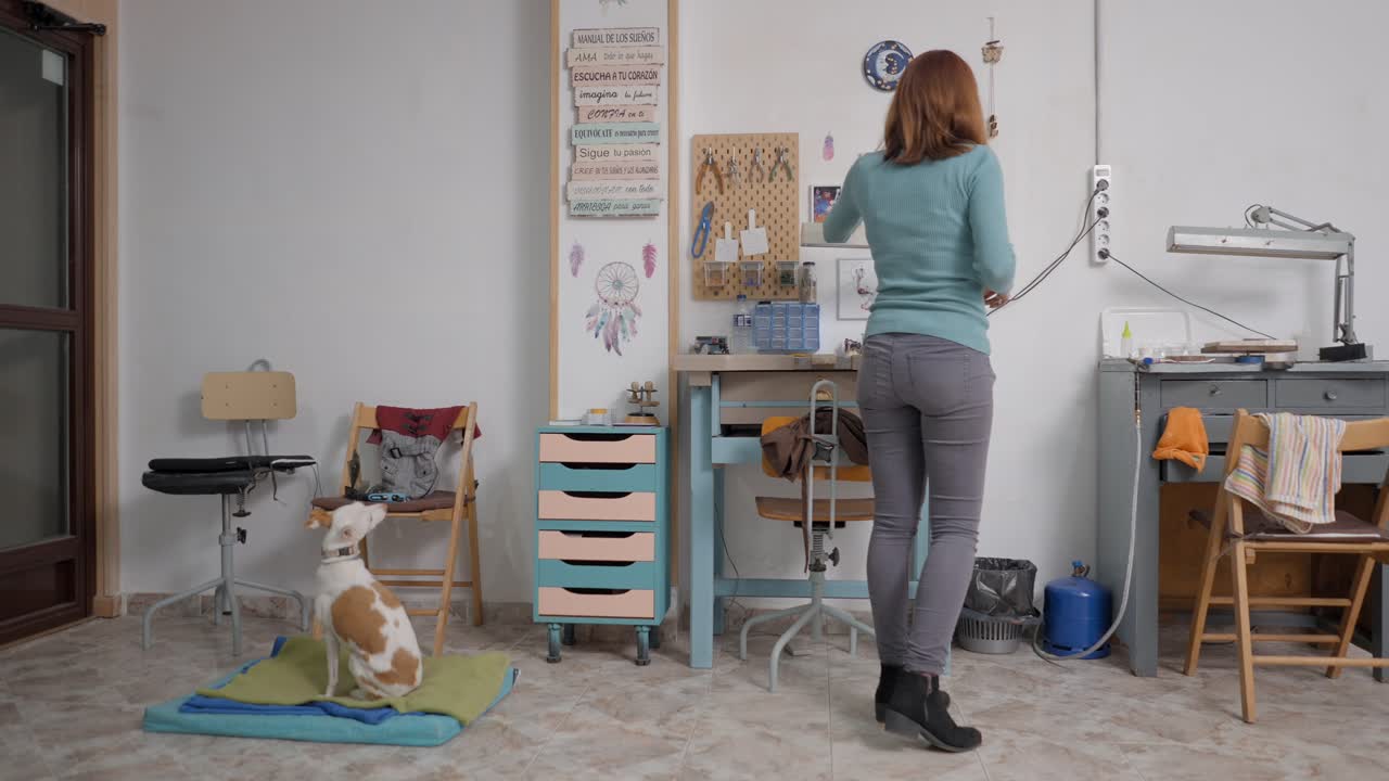 Woman training a dog in a jewelry workshop