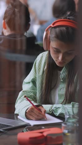 una mujer joven estudiando en un café.
